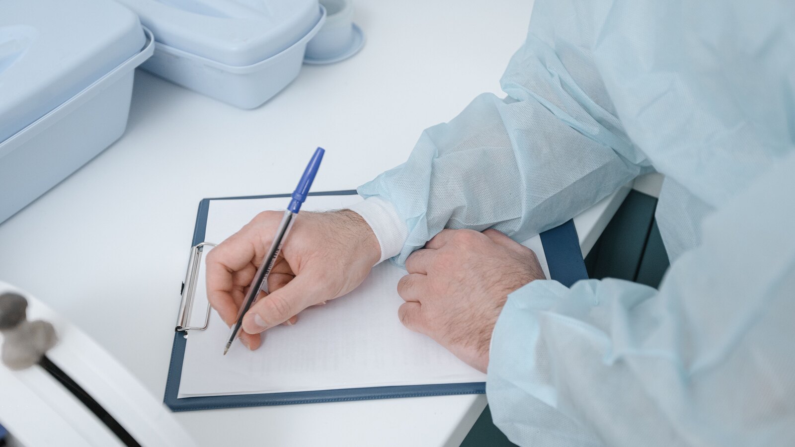 A dermatologist making notes during a consultation